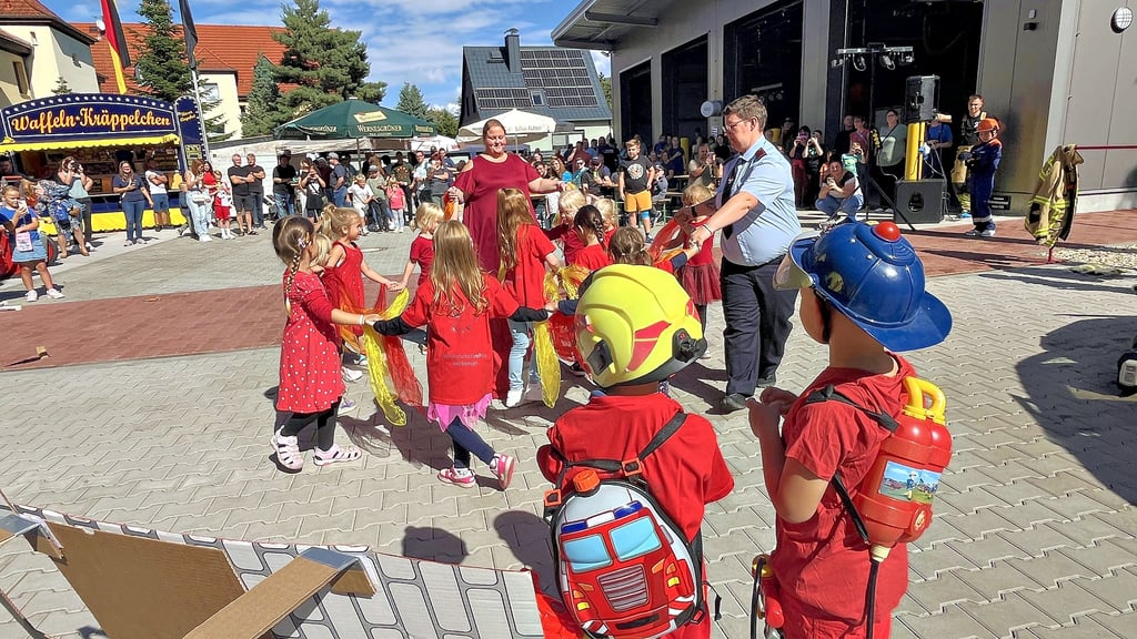 Kinder der Kita „Villa Kunterbunt“ singen und tanzen, um den Feuerwehrkameraden mit einem bunten Programm ihre Dankbarkeit zu zeigen.
