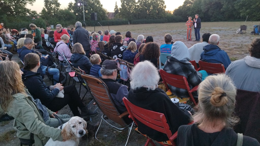 Christiane Nierle (hinten links) und Olaf Meining (hinten rechts, den Zuschauern zugewandt) eröffneten am 29. August 2025 auf der Festwiese an den Kämmereiteichen die ersten Salzwedeler Kulturnächte.