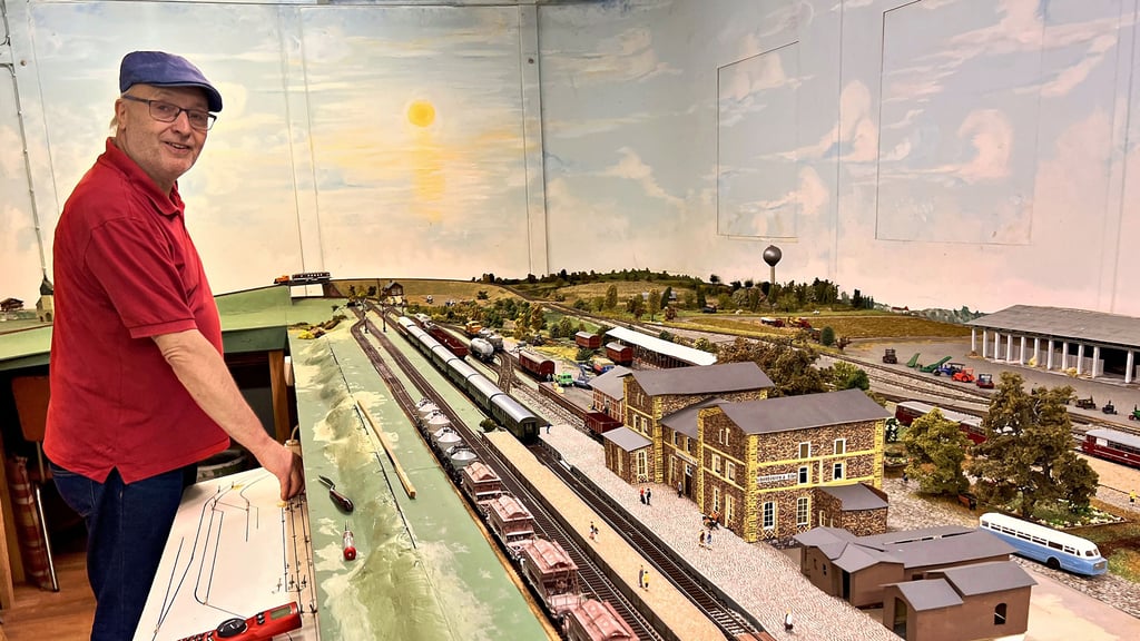 Am digitalen Bedienpult der großen Anlage steht Olaf Bauermeister aus Bismark. Vor ihm befindet sich die nachgebaute Bahnhofsanlage von Schönhausen, wie sie sich zu DDR-Zeiten präsentierte. Hinter dem Bahnhof sieht man die roten Schienenbusse der Kleinbahn.