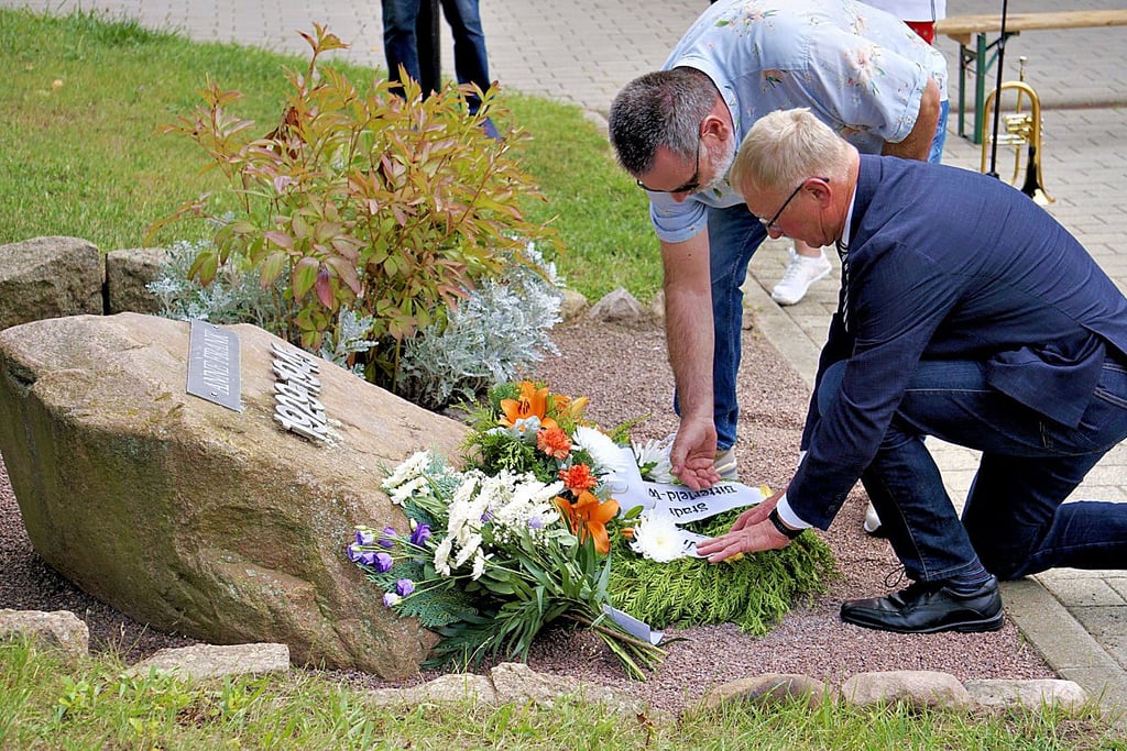 Bitterfeld-Wolfens Stadtratsvorsitzender Henning Dornack und Oberbürgermeister Armin Schenk (r.) bei der Kranzniederlegung