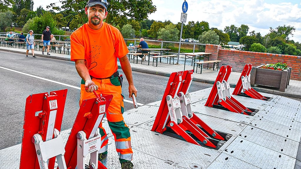 Sandro Brüggemann vom Bauhof Havelberg zeigt beim Bootskorso, wie leicht die Sperre abgeklappt werden kann, wenn der Weg etwa für Rettungsfahrzeuge schnell freigemacht werden muss.