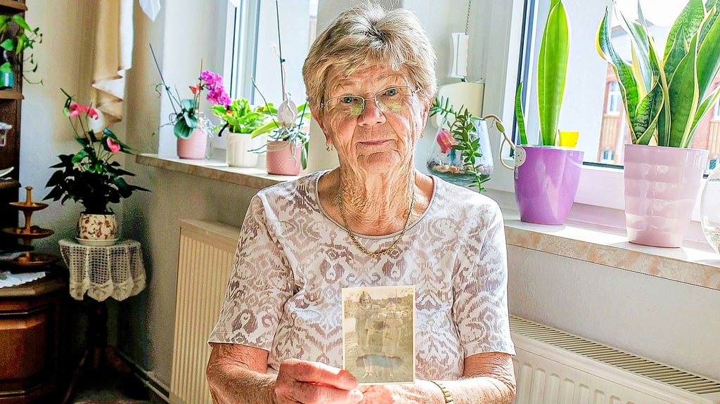 Gisela Lukasczyk zeigt ein Foto mit ihren Geschwistern aus dem Jahr 1947. Auf dem Foto tragen sie und ihre Schwester Käthe die Dirndl aus der Heimat.