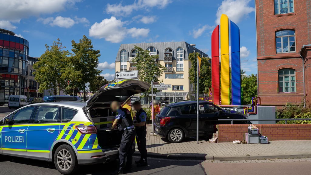 Nach dem Unfall in Wittenberg nehmen Polizisten den Schaden auf.