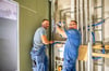 Robert Klotz (l.) und Max Zschach arbeiten in einem der neuen Bäder an der Sanitärinstallation.