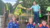 Die Baumpflanzchallenge 2025 ist geschafft: Hessens Wehrleiter André Bindseil-Almes (links) und Ortsbürgermeister Hans-Werner Goy reichen sich über dem neuen Apfelbaum die Hände. Mit ihnen freut sich der Feuerwehrnachwuchs: Max Nehrig, Stella Almes und Lukas Schulz (von links).