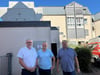 Caritas-Bauchef Winfried Preden, Steffen Julius von der Firma Böhle und der Einrichtungsleiter des Kardinal-Jaeger-Hauses in Oschersleben, Andreas Kretschmer (v.l.n.r.) vor der Wärmepumpe, die unter dem Schallschutz auf dem Dach der Garage versteckt ist.