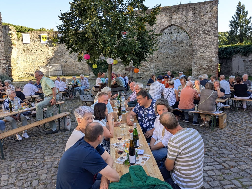 Die Mitgleider des Vereins haben den Burghof im Vorfeld liebevoll geschmückt. Und die Laune ist bei Weißwein, Rotwein und Rosé besonders ausgelassen.