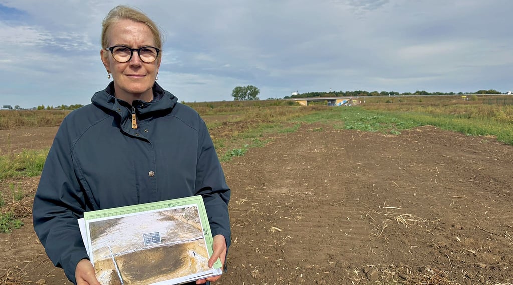 Dietlind Paddenberg zeigt das Foto einer mit Abfällen und Tierknochen gefüllten Grube, die im künftigen Industriepark gefunden wurde.
