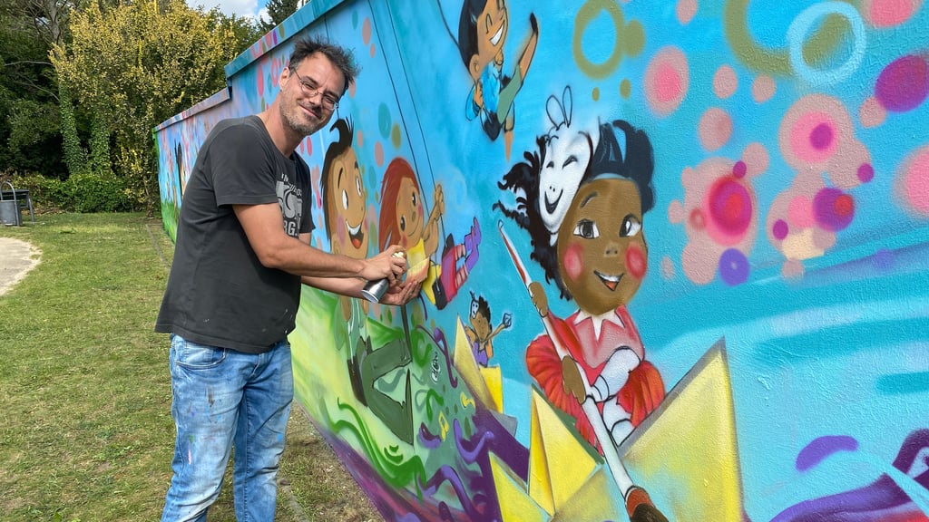 Der Graffiti-Künstler Christian Grams verschönert die Wand am Spielplatz an der Deichstraße in Burg mit vielen bunten Motiven.