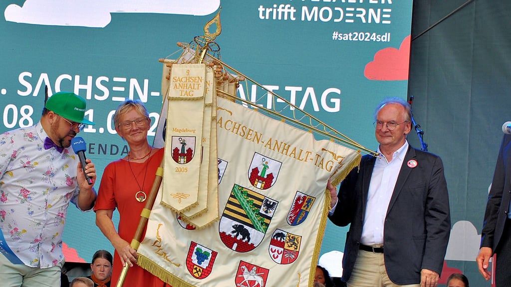 Ministerpräsident Reiner Haseloff überreicht Bernburgs Oberbürgermeisterin Silvia Ristow die Sachsen-Anhalt-Fahne für das Landesfest 2026.