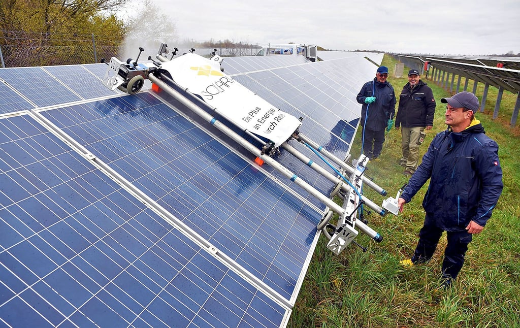 Mitarbeiter einer Spezialfirma reinigen eine Photovoltaikanlage am Flugplatz in Köthen.