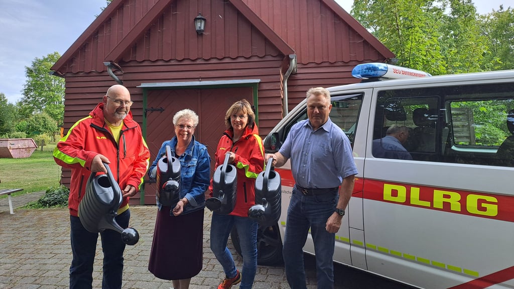 Mathias Becker, Vorsitzender der DLRG-Ortsgruppe Benneckenstein, Gabriele Schütt von der Friedhofsverwaltung, Ramona Bothur, Schatzmeisterin der Ortsgruppe, und Bürgermeister Ronald Fiebelkorn (von links) präsentieren die neuen Gießkannen für die städtischen Friedhöfe im Oberharz.