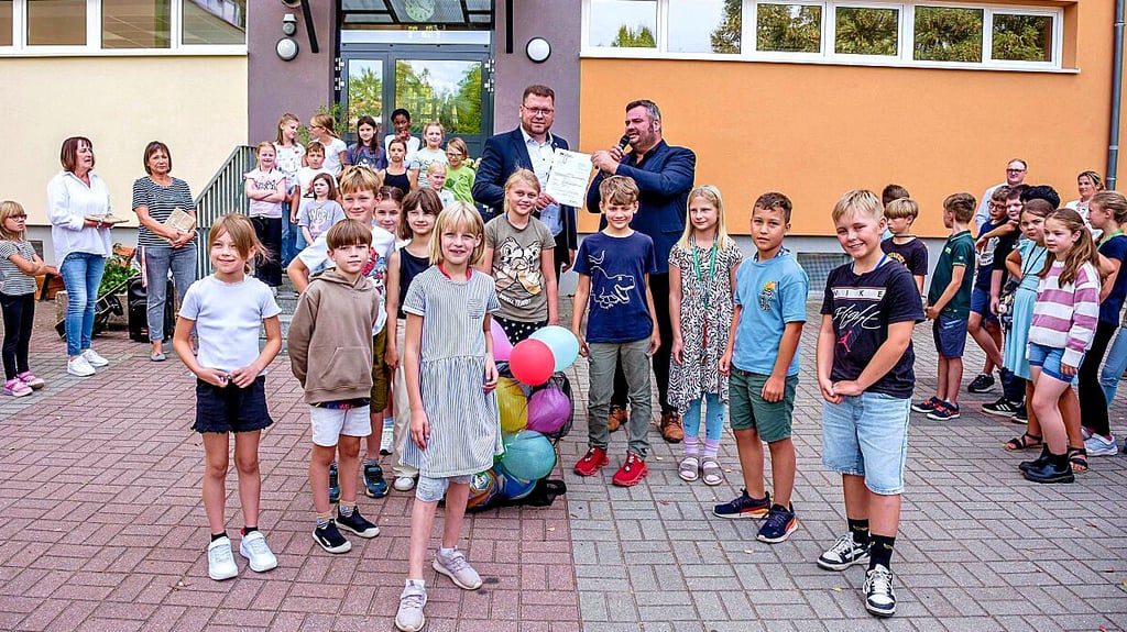 Landrat Christian Tylsch übergibt den Bescheid und die Bälle.