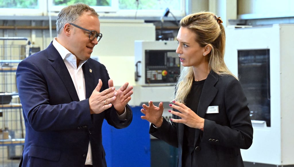 Mario Voigt (l, CDU), Ministerpräsident von Thüringen, spricht mit Karlotta Gründobler, Geschäftsführerin der Eliog Industrieofenbau GmbH. Voigt sieht überbordende Bürokratie als zunehmende Belastung für Thüringer Unternehmen.