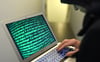 Das Symbolbild  soll einen Cyberkriminellen  an einem Laptop darstellen.