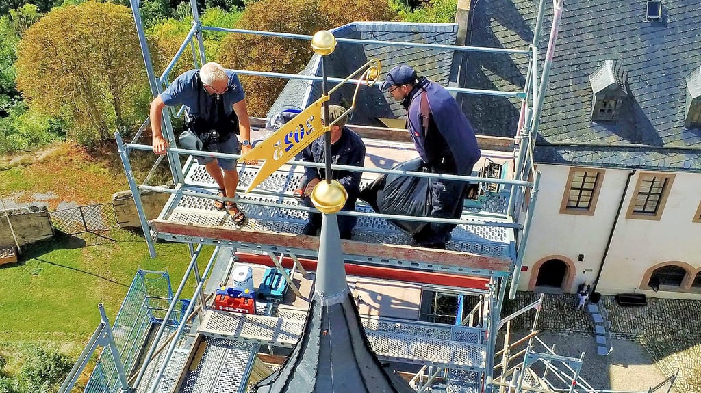 Jörg Otto und Dirk Reichardt (r.) montierten den Knopf und die Wetterfahne auf den sanierten Turm. Begleitet wurden sie durch Steffen Schellhorn (l.) von der Kulturstiftung.