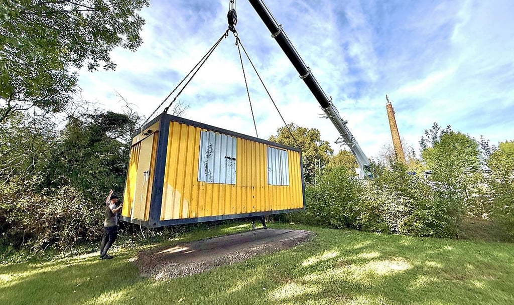 Mit einem Großkran wird der Container auf das Gelände gehoben.