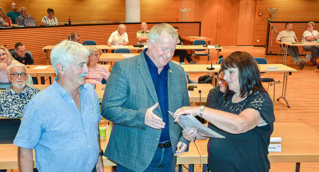 Sabine Ernst überreicht dem Staßfurter Bürgermeister René Zok (Mitte) und Stadtratsvorsitzenden Peter Rotter die Unterschriftensammlung von den Anliegern der Erich-Weinert-Siedlung, die gegen den derzeitig geplanten Spielplatzstandort sind.