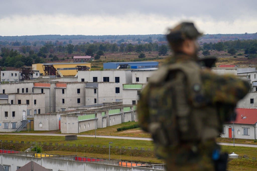Ein Soldat steht in der Übungsstadt „Schnöggersburg“ auf dem Dach eines Gebäudes.