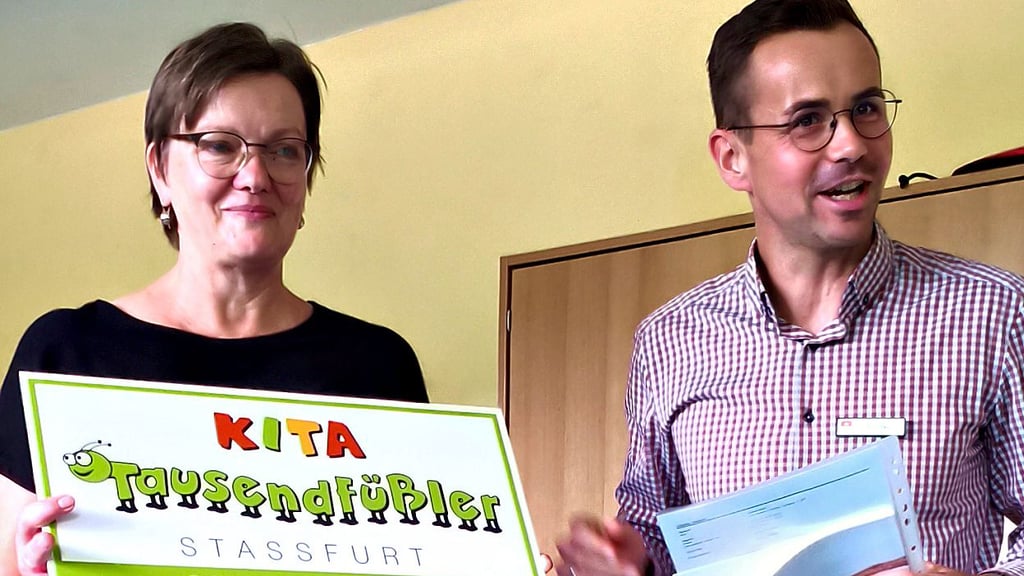 Susann Birnbaum, Leiterin der Kindertagesstätte, und Robert Göbke, amtierender Fachdienstleiter, präsentieren das Eingangsschild der „Tausendfüßler“.