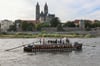 Die „Ulmer Schachtel“, ein Nachbau alter Donauschiffe, die für Transport und Handel genutzt wurden, passiert den Dom und Domfelsen auf der Elbe in Magdeburg.
