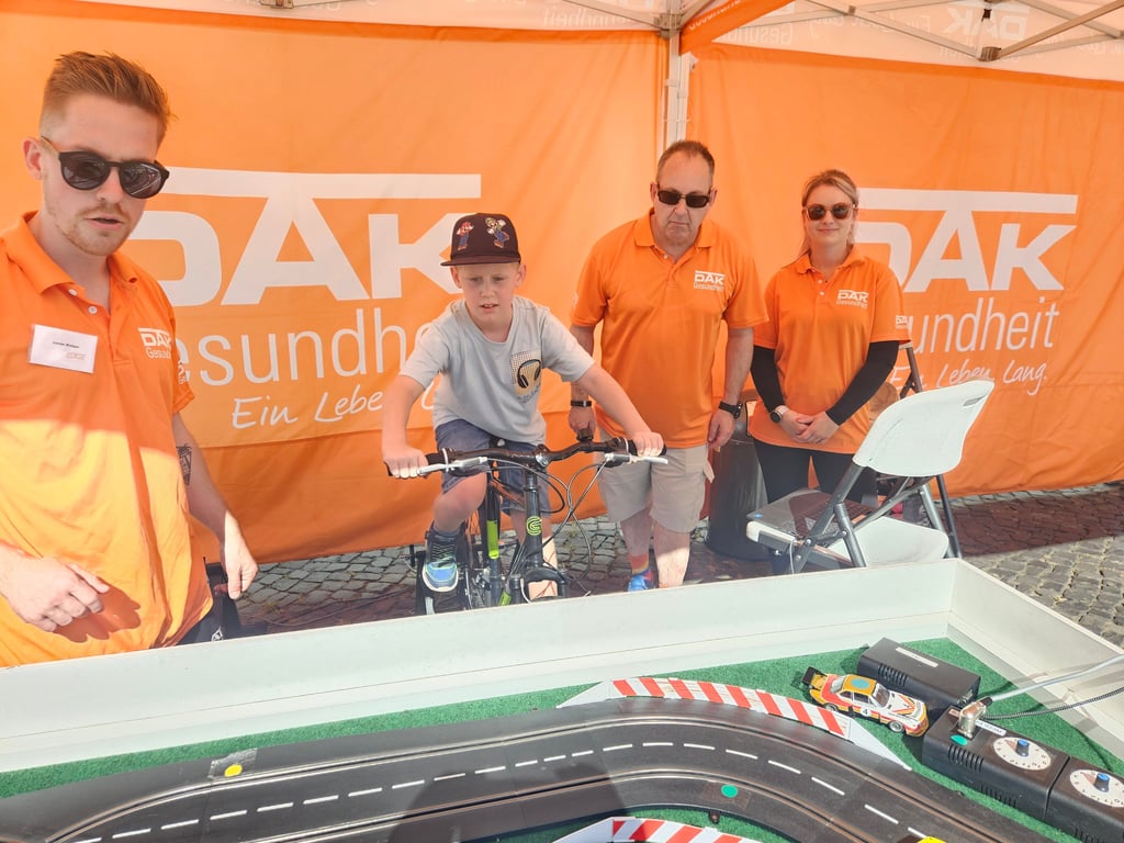 Matteo testet eine mit Muskelkraft vom Fahrrad betriebene Autorennbahn.