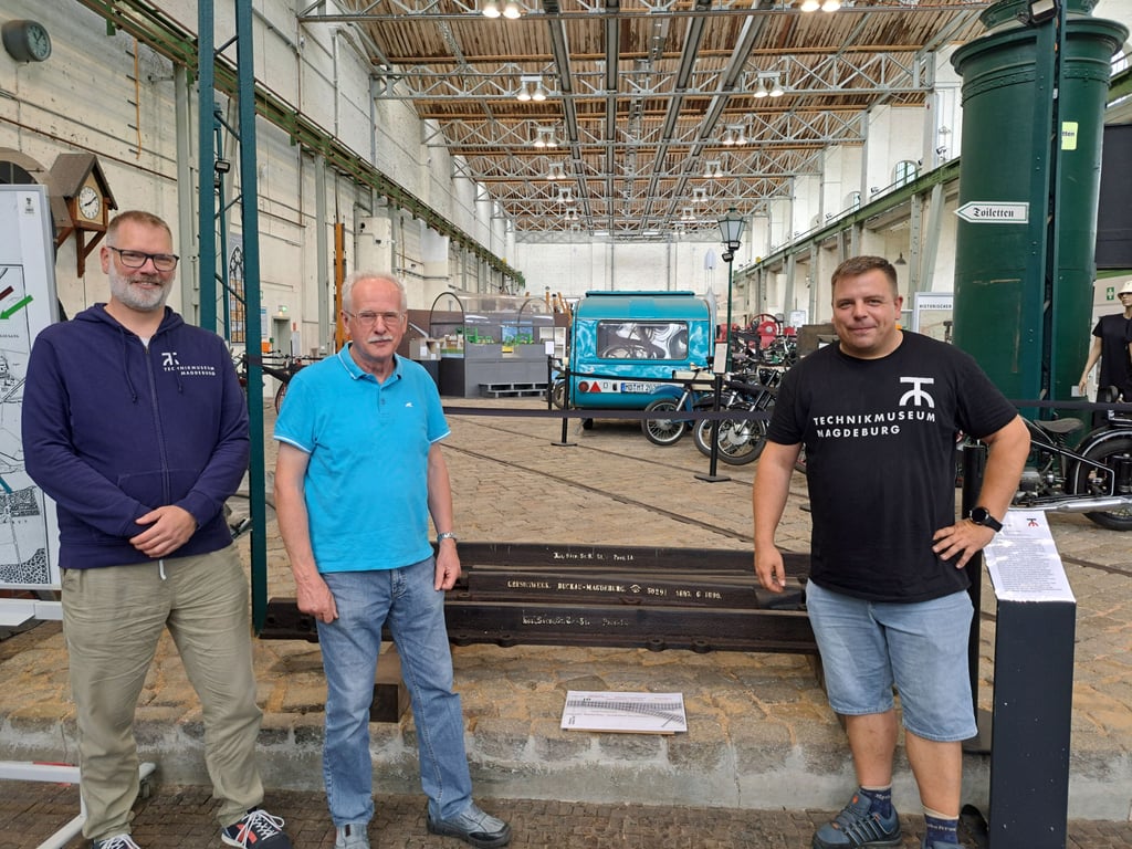 Bernd Kramer (Mitte) übergibt die Grusonweiche im Technikmuseum an den Museumsdirektor Hajo Neumann (links) und den Sammlungsleiter Christian Marlow.