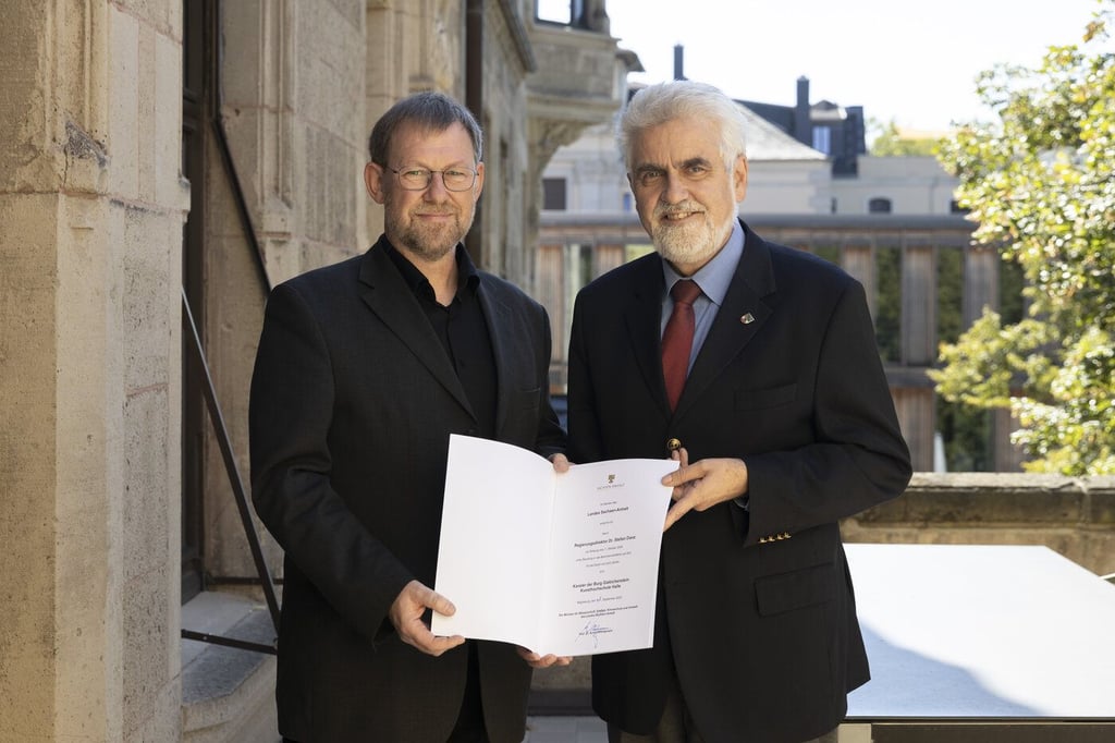 Stefan Danz (links) erhielt von Armin Willingmann die Ernennungsurkunde für den neuen Kanzler.