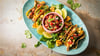 Richtig stilecht werden Hähnchen-Tacos erst mit Zugaben wie der mexikanische Tomatensalsa „Pico de Gallo“, argentinischer Kräutersauce „Chimichurri“, Avocado, gegrillter Ananas, Koriander und Limetten.