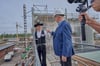 Auf baldige Fertigstellung: Dachdeckermeister Sven Hinrichs und Halles Handwerkskammerpräsident Thomas Keindorf stoßen beim Richtfest auf den Campus Handwerk an.