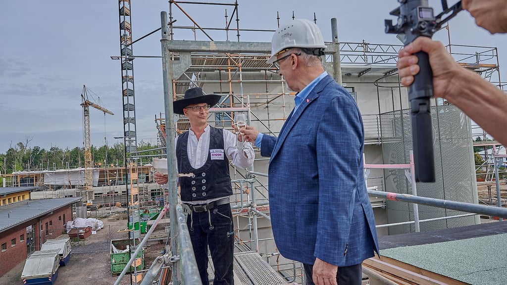 Auf baldige Fertigstellung: Dachdeckermeister Sven Hinrichs und Halles Handwerkskammerpräsident Thomas Keindorf stoßen beim Richtfest auf den Campus Handwerk an.