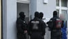 Vermummte Polizisten stehen am Mittwochmorgen vor einem Haus in der Sandstraße in Gardelegen. 