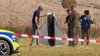 Einsatzkräfte von Polizei und Militärpolizei sichern Teile einer beschädigten Drohne.