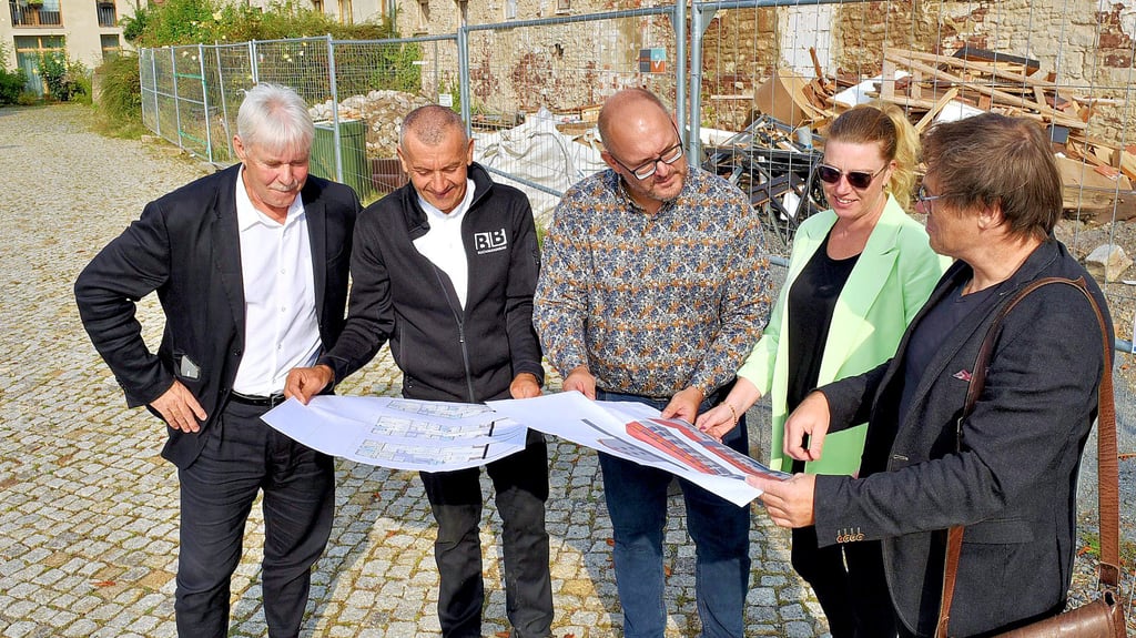 Rainer vor der Straße (Unternehmerverband), Steffen Lochner (Buchmann Bau), Marcus Politt und Anja Joksch vom Leader-Management sowie Architekt Oliver Flügel (von links) werfen einen Blick in die Pläne für den Neubau.