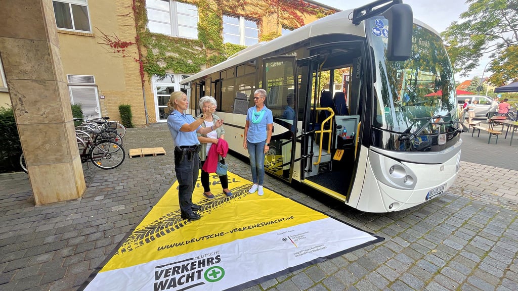 Polizeihauptkommissarin Bianca Müller erklärt Annemarie Eckwert den toten Winkel am Bus von Fahrerin Beate Schwertfeger (v.l.).