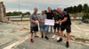 Oliver Pieper, Abteilungsleiter Fußball bei Fortuna Dingelstedt (links), und Fortuna-Chef Stephan Blume (rechts) nehmen von Stefan Wuthenow, Andy Streckel und Kevin Kalweit (von links) in den resten des abgebrannten Vereinsheims die Spende des Dartsclubs Halberstadt entgegen.
