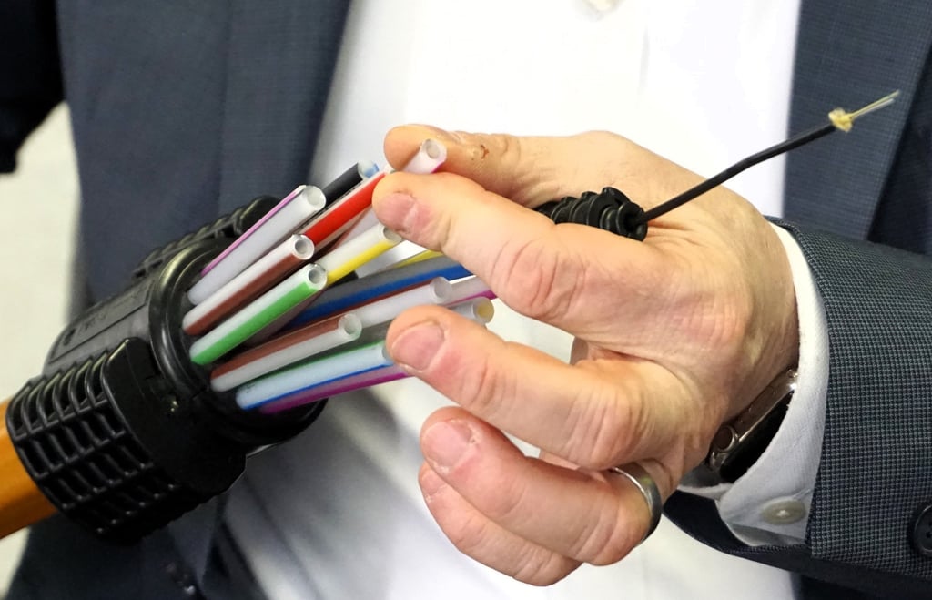Mit Druckluft wird die dünne Glasfaser (schwarz, rechts oben) in die Kabel des Bündelungsrohrs eingeblasen.