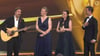 Sänger Max Giesinger (links) trug bei der Verleihung der „Goldenen Henne“ an Nadja Benndorf und Nicole John aus Magdeburg seine Laudatio singend vor. Für die beiden Gründerinnen des Vereins Kinderklinikkonzerte textete er eigens seinen Hit „80 Millionen“ um.