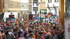 Teilnehmende des CSD ziehen mit Regenbogenfahnen und Plakaten durch die Innenstadt.
