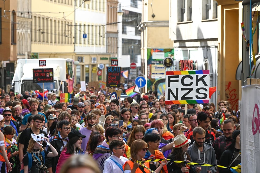 Teilnehmende des CSD ziehen mit Regenbogenfahnen und Plakaten durch die Innenstadt.