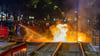 Feuerwehrleute löschen einen Brand auf Gleisen im Leipziger Süden. Dort hatten am Samstagabend Unbekannte randaliert und Polizisten angegriffen.