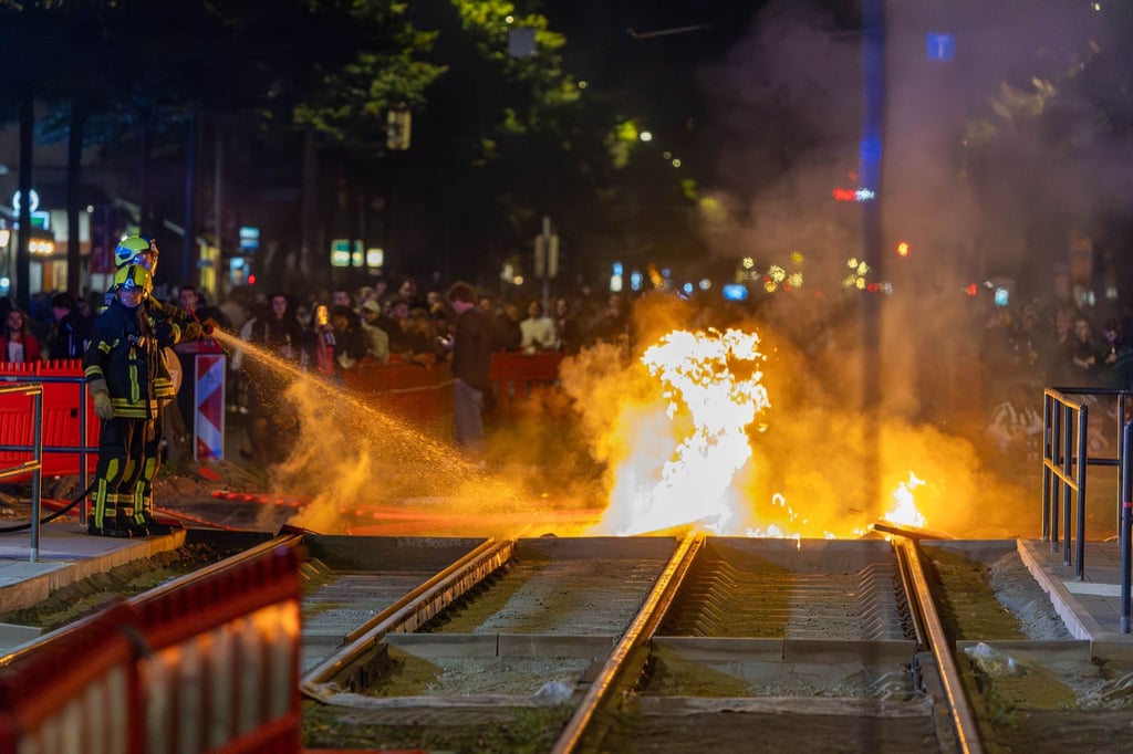 Feuerwehrleute löschen einen Brand auf Gleisen im Leipziger Süden. Dort hatten am Samstagabend Unbekannte randaliert und Polizisten angegriffen.