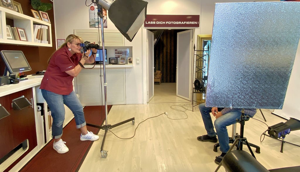 Ines Hounmenou, Inhaberin von „easy: Foto - Portrait“ portraitiert einen Mann für seinen neuen Ausweis.