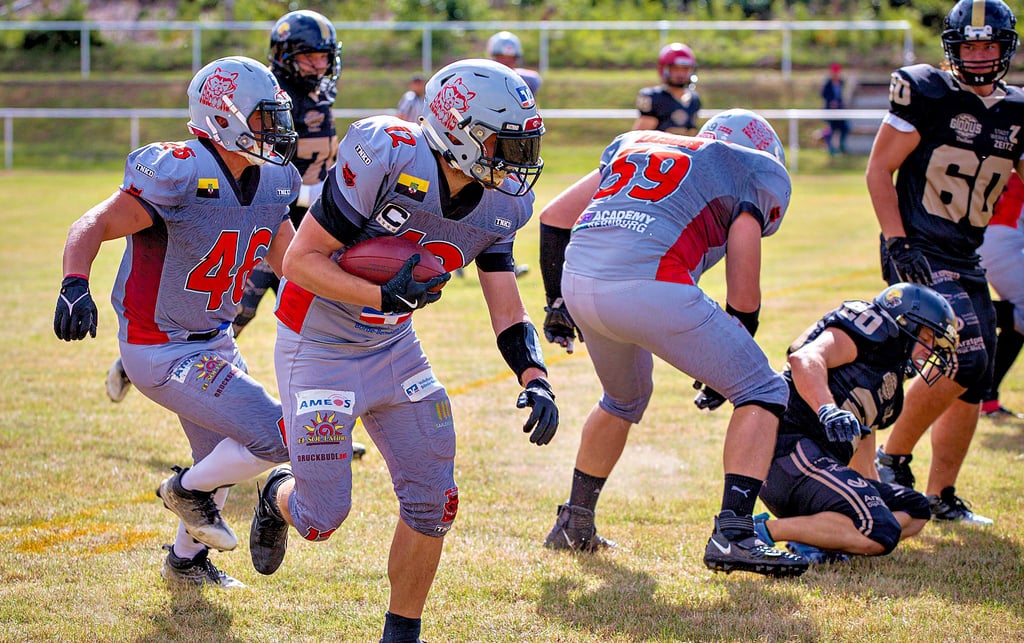 Die American-Football-Mannschaft „Salzland Racoons“ in Aktion. Wide Receiver Sebastian Tittmann (am Ball) wird von Victor Latzel (links mit der Nummer 46) und Eric von Ramin (Nummer 59) abgeschirmt.