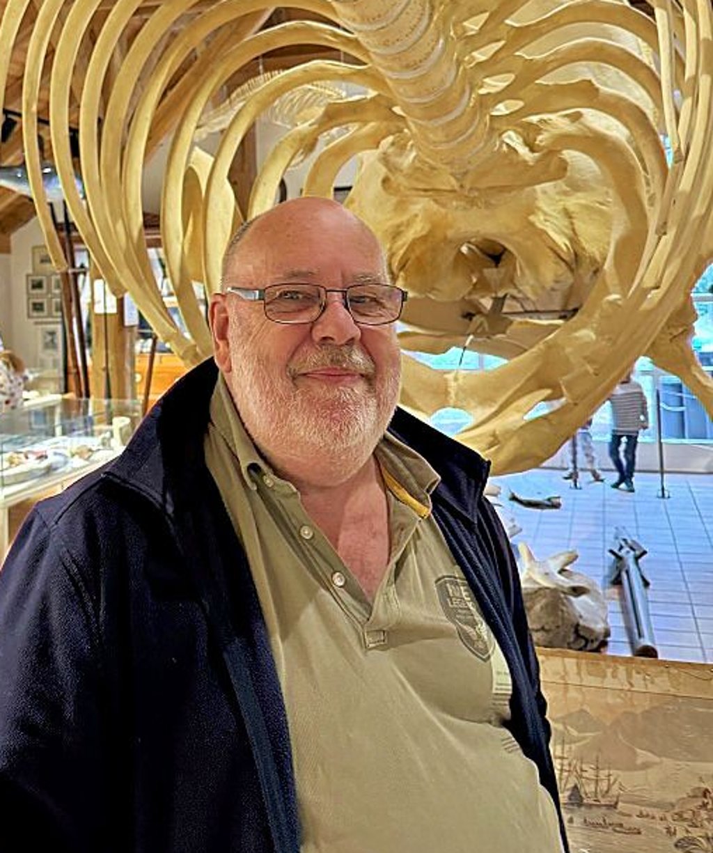 Museumsführer Tjard Steemann mit Pottwal-Skelett.