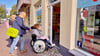 Olaf Diener, Örtlicher Teilhabemanager von Bitterfeld-Wolfen, schiebt den Rollstuhl von Vanessa Wegewitz bei der Wheelmap-Aktion in der Burgstraße.