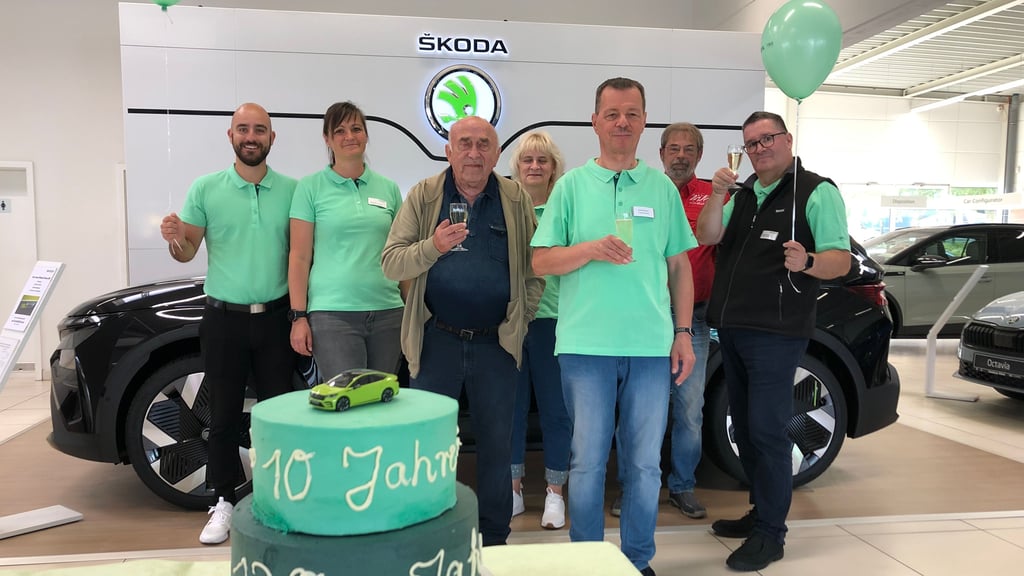 Standort-Leiterin Susan Kittel (2.v.l.) empfing mit ihrem Team (in grünen Shirts) am Samstag viele Besucher im Weißenfelser Skoda-Autohaus, darunter Reinhold Schmidt (3.v.l.) und Sven Pöhl (2.v.r.). Im Hintergrund steht der neue Elektro-Skoda Elroq.