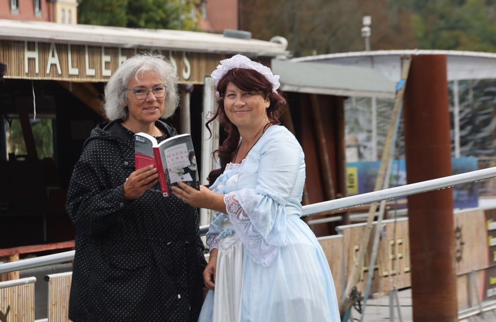 Autorin Christina Auerswald (links) und Stadtführerin Beate Krauße als Magdalene laden zu einer vergnüglichen und lehrreichen Floßfahrt auf der Saale ein.