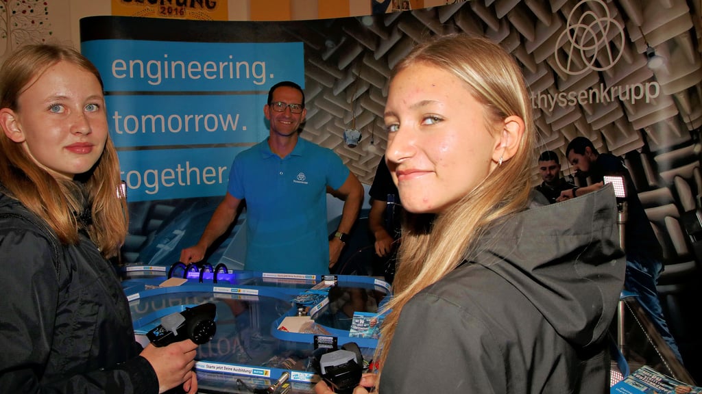 Lea (r.) und Hanna lassen hier die Spielzeugautos am Stand von Thyssenkrupp fahren. Fragen rund um die Ausbildung beantwortet hier Benjamin Reimann.