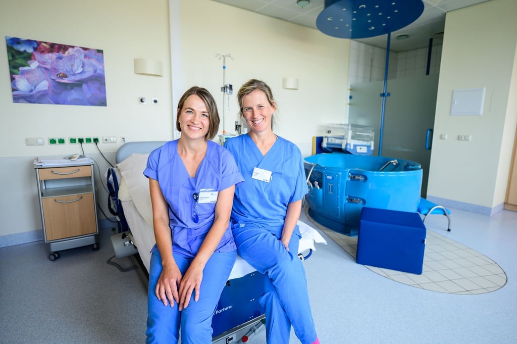 Die Hebammen Antje Kuhrau (l) und Franziska Pfeil sitzen in einem Kreißsaal des Klinikums Lüneburg. Seit diesem Monat können Frauen in Begleitung von zwei Hebammen entbinden.